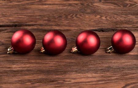 Four red Christmas balls on a wooden backgroundの写真素材