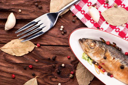 Small fried fish Baltic herring in a bowl on a table with spices top viewの写真素材