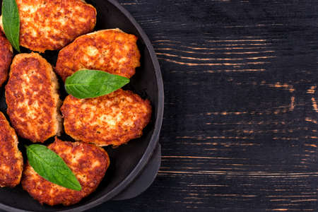 Part of the frying pan with fried cutlets on a wooden background top viewの写真素材