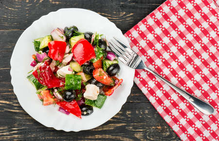 Plate Greek salad with a fork on the table, top viewの写真素材
