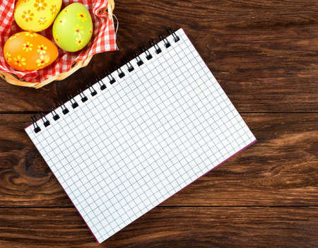 Blank notebook on a table with eggs for Easter greetingsの写真素材