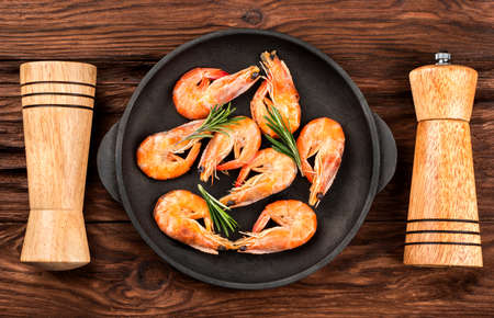 Fried shrimp with rosemary in a pan with salt and pepper, top viewの写真素材