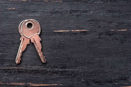 Two metal silver key from the lock on an empty dark wooden backgroundの写真素材