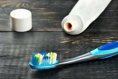 Toothbrush with toothpaste open on a wooden background