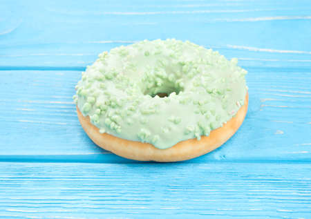 Sweet donut with green glaze on a wooden backgroundの写真素材