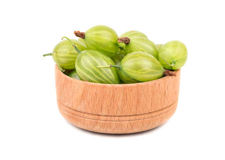 Wooden capacitance filled with green gooseberries isolated on a white backgroundの写真素材