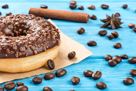 Delicious chocolate donut with scattered beans on the table close-upの写真素材