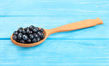 Wooden spoon with fresh blueberries on the tableの写真素材