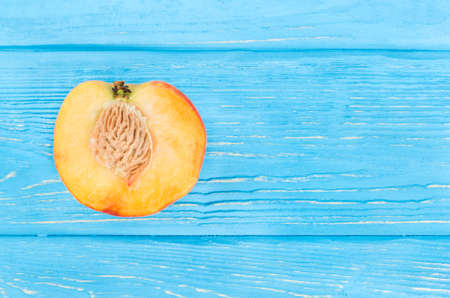 Juicy peach half on an empty wooden background, top viewの写真素材