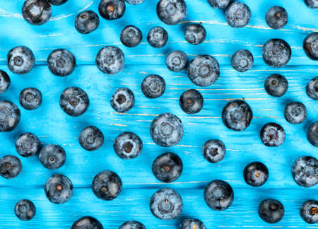 Background of fresh blueberries scattered on table, top viewの写真素材