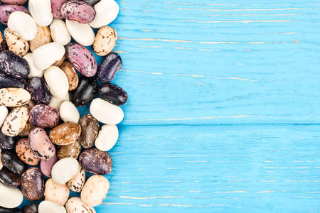 Colorful kidney bean on a blank wooden background, top view