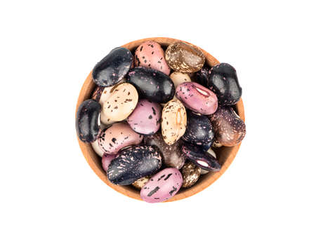 Wooden bowl filled with colored beans isolated on a white background, top view