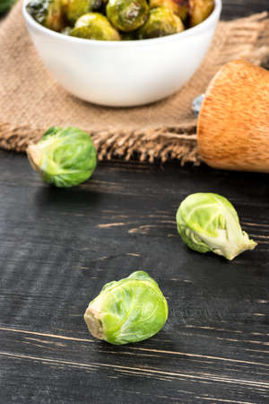 Bowl with fried Brussels sprouts and ingredients on a wooden backgroundの写真素材
