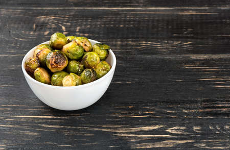 Bowl with fried Brussels sprouts on a dark tableの写真素材