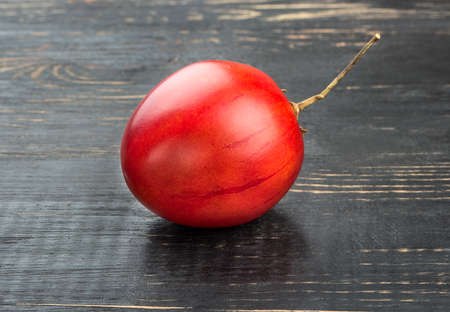 Fresh fruit tamarillo on a dark wooden backgroundの写真素材