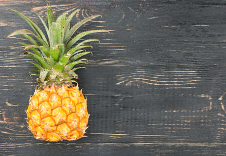 Ripe pineapple on a small empty wooden backgroundの写真素材