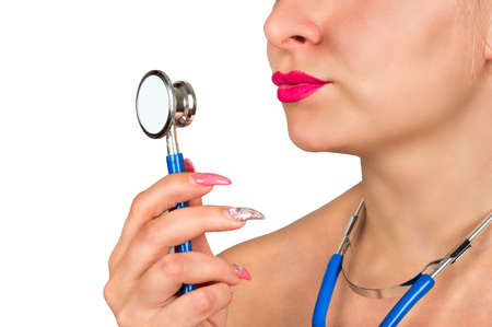 Woman doctor without a coat with a stethoscope in her hand closeupの写真素材