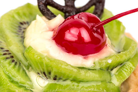 Slices of kiwi, cherry on tart and cream close-upの写真素材