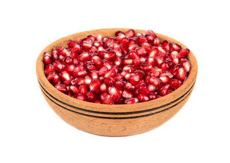 Pomegranate seeds in a wooden bowl isolated on white backgroundの写真素材