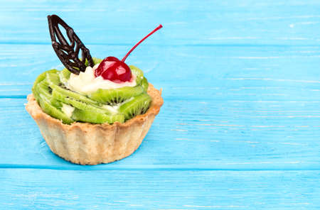 Delicious tart with kiwi fruit on a blank wooden backgroundの写真素材