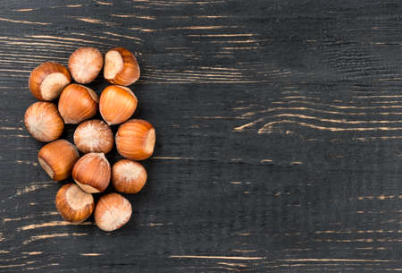 Several hazelnuts in the shell on a blank wooden background, top viewの写真素材