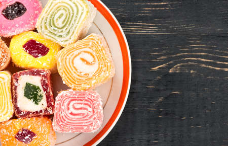 Part of dish with pieces of turkish delight on a blank wooden backgroundの写真素材