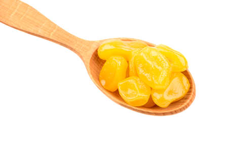 Wooden spoon full of yellow kumquat close up on a white backgroundの写真素材