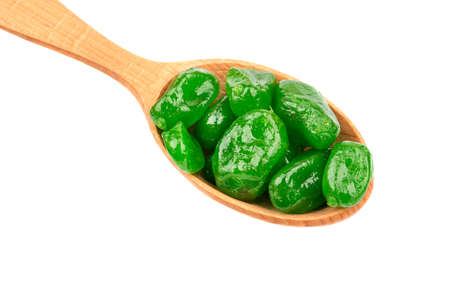 Dried green kumquat in a wooden spoon closeup on white backgroundの写真素材