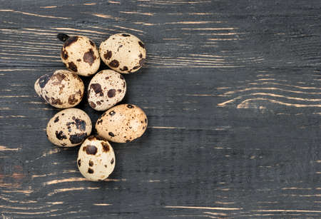 Some raw quail eggs on a wooden background, top viewの写真素材