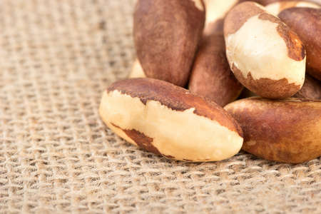 Dry Brazil nuts on burlap, close upの写真素材