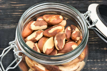 Open jar filled with Brazil nuts close upの写真素材