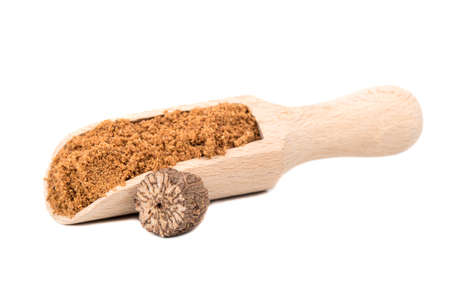 Nutmeg powder in the scoop with a half walnut on white backgroundの写真素材