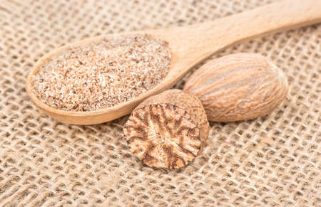 Spice nutmeg in the spoon on sackcloth close upの写真素材