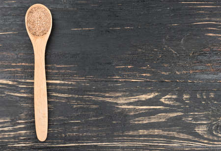 Nutmeg powder in a spoon on an empty wooden background, top viewの写真素材