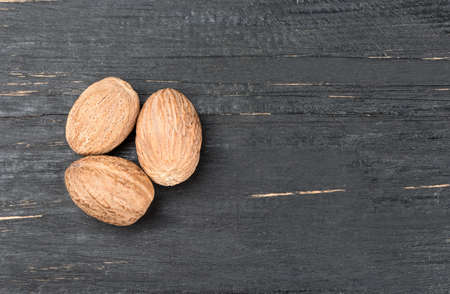 Three dry nutmeg on an empty wooden backgroundの写真素材