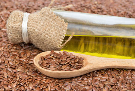 Bunch of the seeds with a spoon and linseed oil in a bottle closeupの写真素材