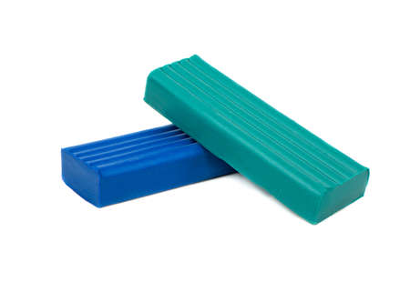 Pieces of green and blue plasticine isolated on white background