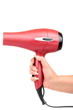 Pink hair dryer in the female hand on white backgroundの写真素材