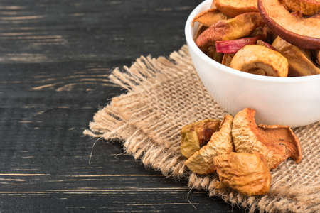 Bowl of dry Apple slices on sackcloth and wooden backgroundの写真素材