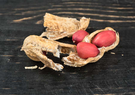 Broken peanut in shell on a wooden background close-upの写真素材