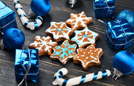 Homemade christmas gingerbread cookies snowflakes in the form of spruce with decorations on wooden backgroundの写真素材