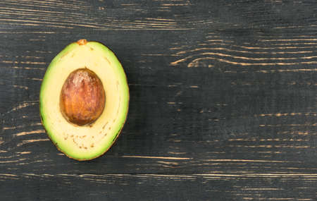 Half of the Hass avocado on an empty wooden backgroundの写真素材