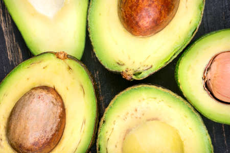 Several halves of fresh avocado closeup, top view