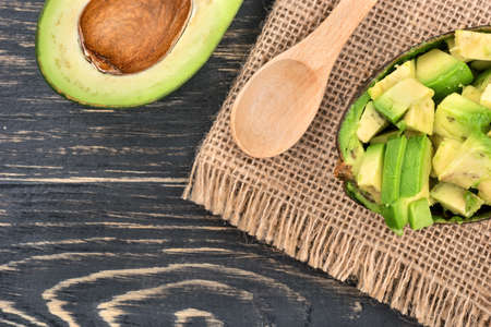 Salad with avocado with a spoon on sackcloth and table, top viewの写真素材