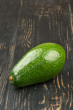 Fresh green avocado fruit on wooden backgroundの写真素材