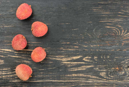 Scattered fruit lychee in the empty shell on wooden background, top viewの写真素材
