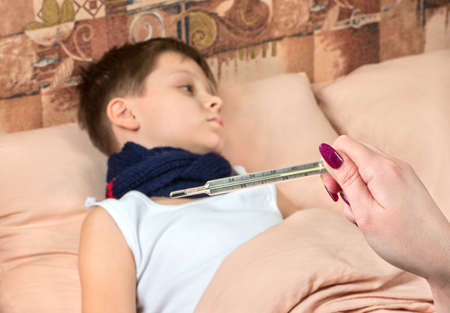 Mom looks great the temperature of the thermometer a sick boyの写真素材
