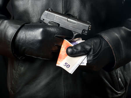 Bandit with a gun and money close upの写真素材