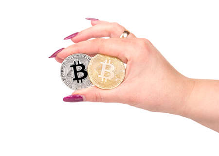 Silver and gold bitcoin coin in female hand on white backgroundの写真素材