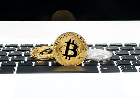 Gold and silver bitcoin coins on laptop keyboard closeupの写真素材